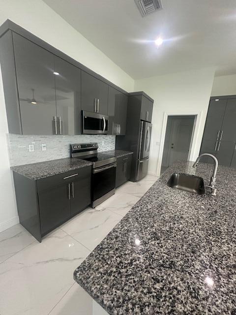 1726 Southwest California Boulevard Port St. Lucie, FL 34953 - Photo 15 of 41 a kitchen with stainless steel appliances granite countertop a sink stove and refrigerator
