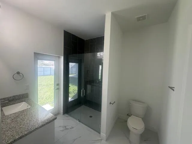 a bathroom with a granite countertop toilet and a sink