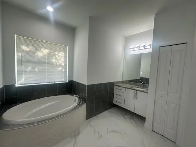 a bathroom with a granite countertop sink a toilet and bathtub