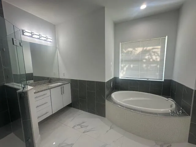 a bathroom with a granite countertop sink a toilet and bathtub