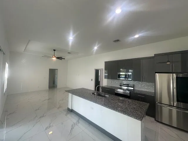 a large kitchen with a refrigerator and a sink