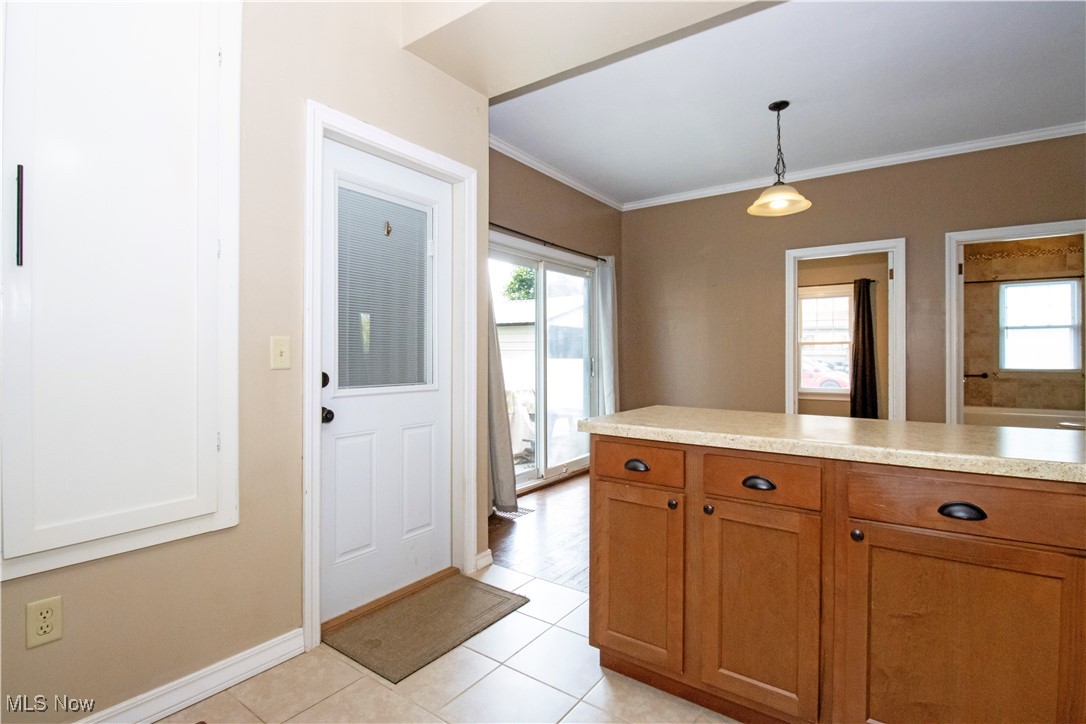 5699 Massillon Road Dalton, OH 44618 - Photo 5 of 24 Kitchen featuring plenty of natural light, crown molding, light tile patterned floors, and pendant lighting