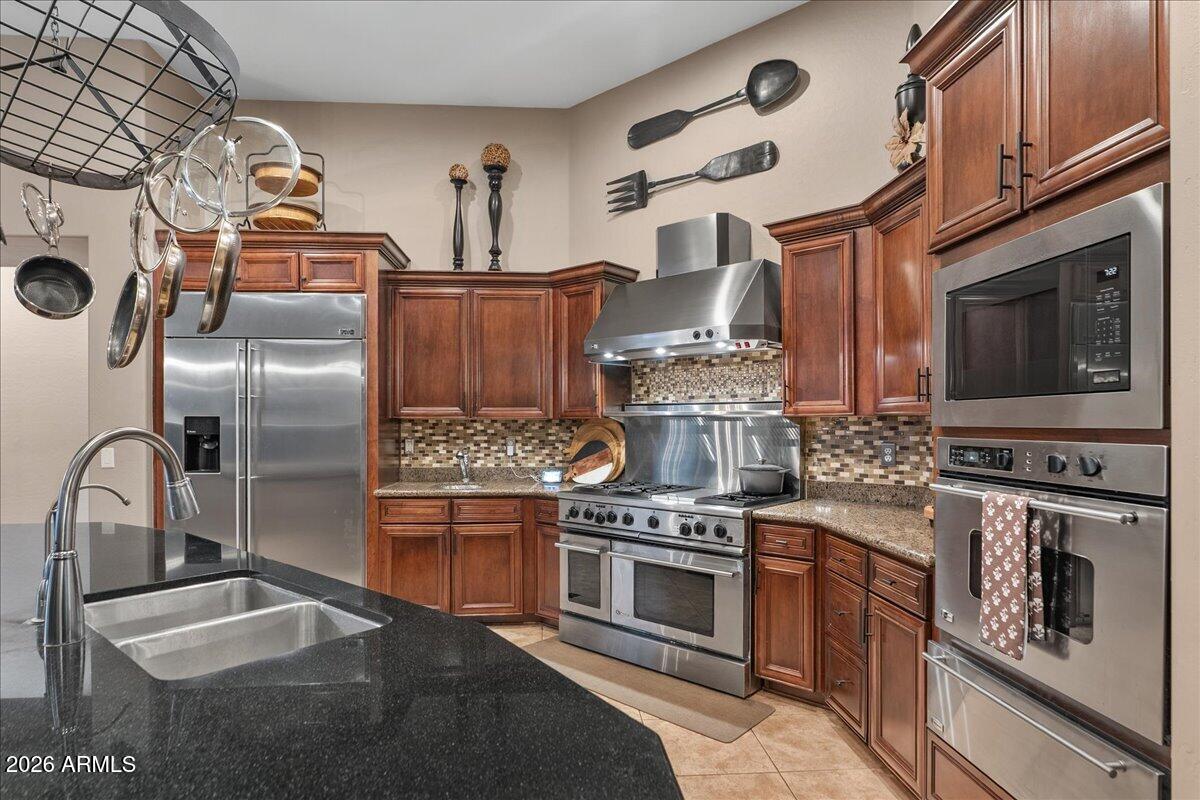 6427 South Magic Court Gilbert, AZ 85298 - Photo 11 of 71 a kitchen with stainless steel appliances granite countertop a stove and a sink