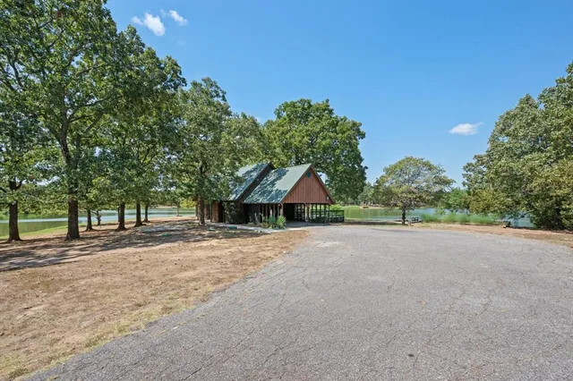 a front view of a house with a yard and trees