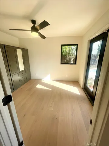 a view of hallway with window and wooden floor