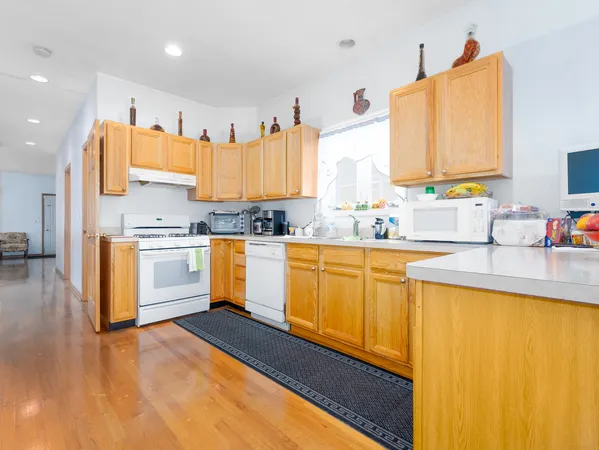 a kitchen with granite countertop white cabinets and white appliances