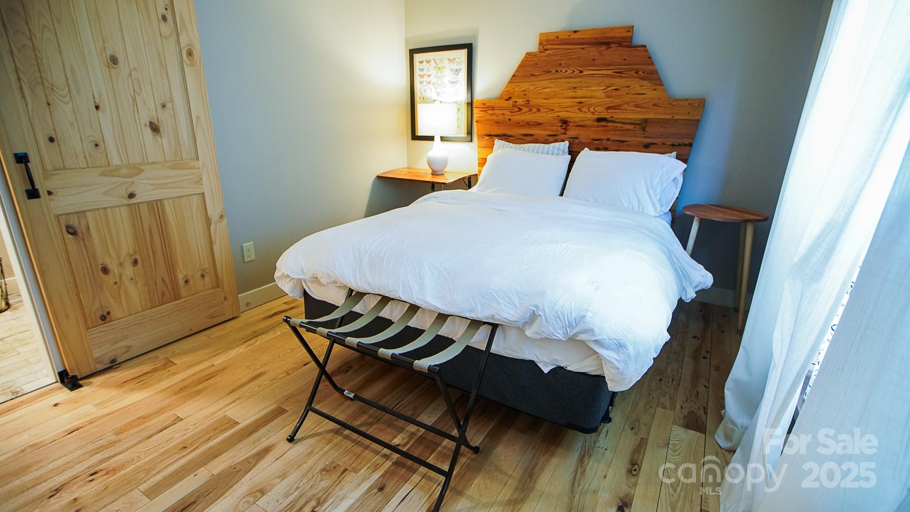 1048 South River Road Sylva, NC 28779 - Photo 24 of 42 a bedroom with a bed and wooden floor