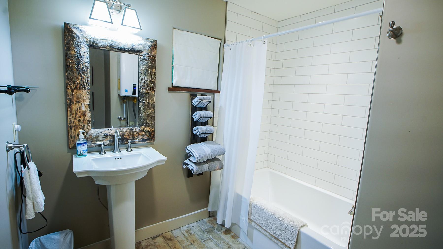 1048 South River Road Sylva, NC 28779 - Photo 25 of 42 a bathroom with a sink a mirror and a shower