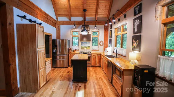 a kitchen with stainless steel appliances granite countertop a refrigerator a stove and a wooden floors