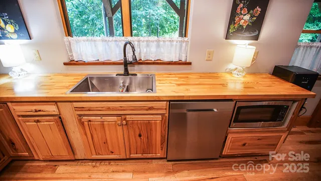 a kitchen with granite countertop a sink a stove and a microwave