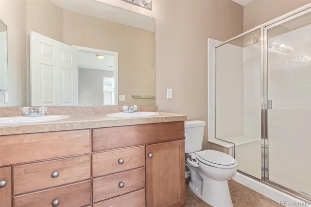 a bathroom with a granite countertop sink a toilet and a mirror