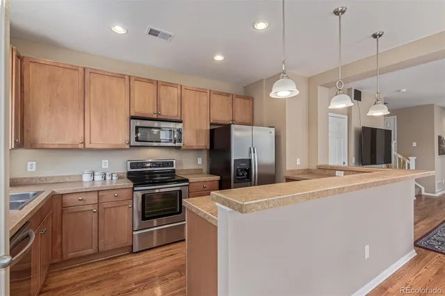 a kitchen with kitchen island a sink stainless steel appliances and cabinets