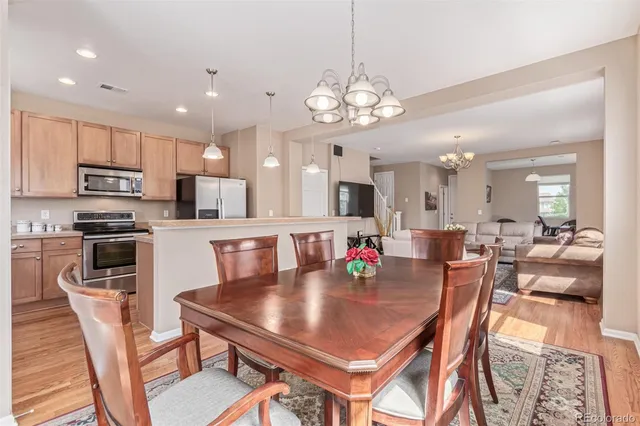 a view of a dining room and a kitchen with a table chairs