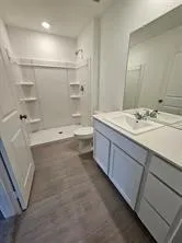 a bathroom with a sink a toilet and shower