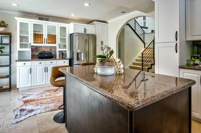 a kitchen with stainless steel appliances granite countertop a sink and a refrigerator