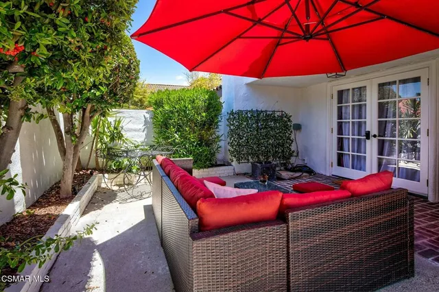 a view of a backyard with table and chairs under an umbrella