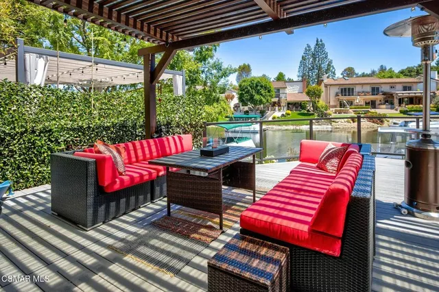 a view of a patio with table and chairs potted plants and floor to ceiling window