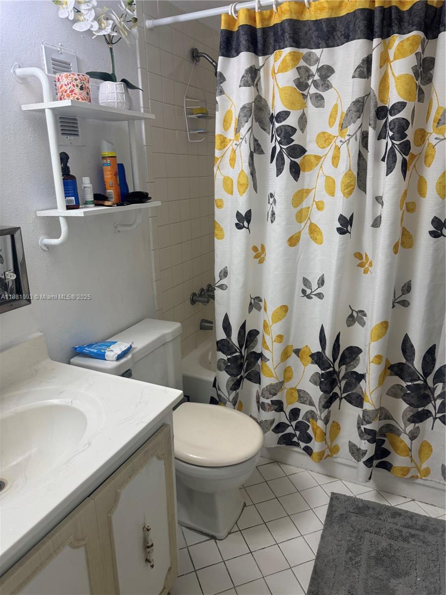 1975 West 44th Place, Unit 505 Hialeah, FL 33012 - Photo 16 of 28 a bathroom with a sink a toilet and a shower curtain