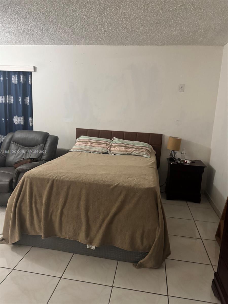 1975 West 44th Place, Unit 505 Hialeah, FL 33012 - Photo 17 of 28 a bedroom with a bed and a window