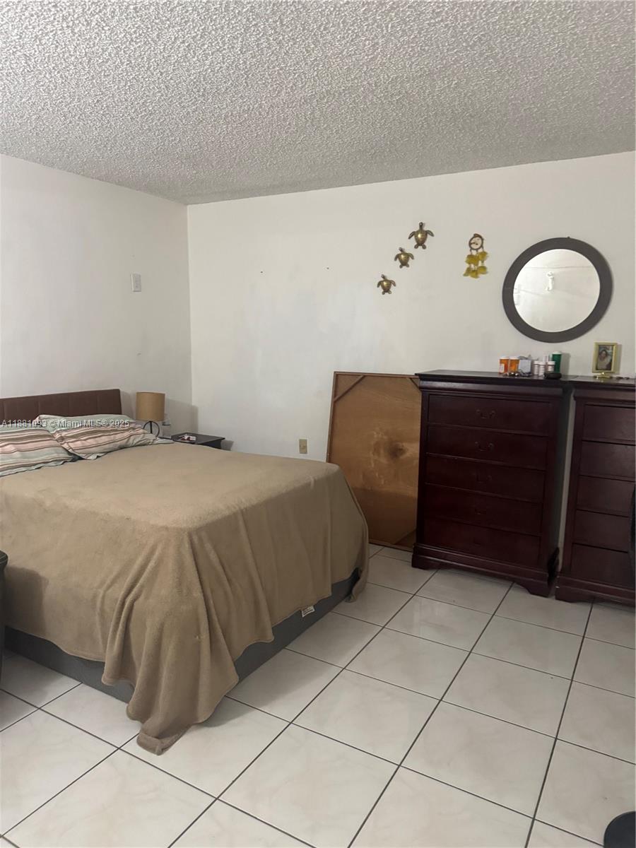 1975 West 44th Place, Unit 505 Hialeah, FL 33012 - Photo 20 of 28 a bedroom with a bed and a cabinets