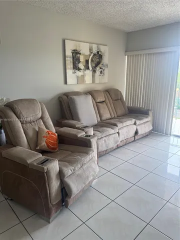 a living room with furniture and painting on the wall