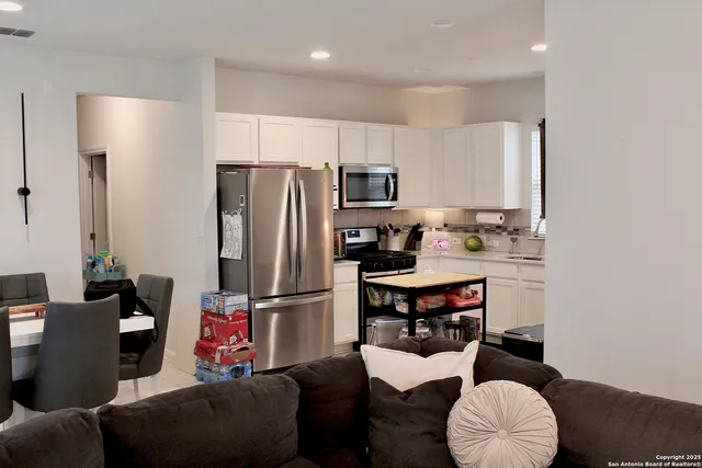 a kitchen with stainless steel appliances kitchen island granite countertop a refrigerator and a sink