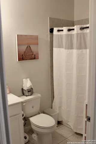 a white toilet sitting next to a white sink and vanity