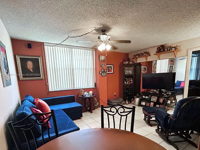 a living room with furniture a flat screen tv and a window