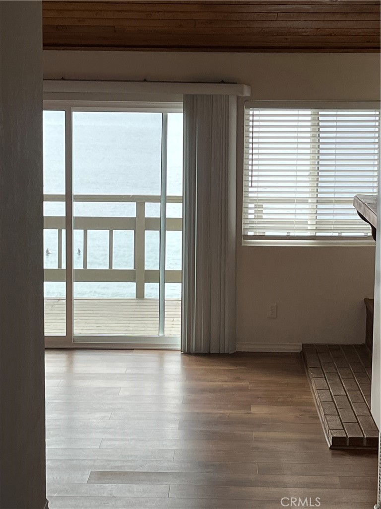 1532 Neptune Avenue Encinitas, CA 92024 - Photo 17 of 36 a view of an empty room with wooden floor and a window