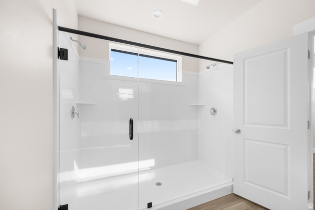 1510 West 600 North, Unit GE 04 Mapleton, UT 84664 - Photo 15 of 21 Shower enclosure featuring a clear glass door with matte black hardware, white paneling, integrated shelving, and a transom window