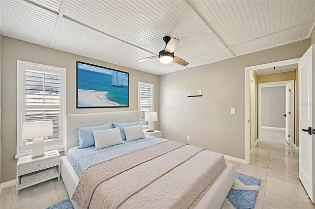 a bedroom with a large bed a chandelier and a window