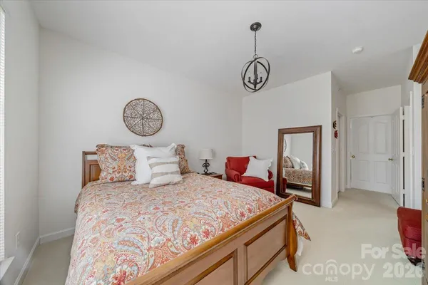 a bedroom with a bed and chandelier