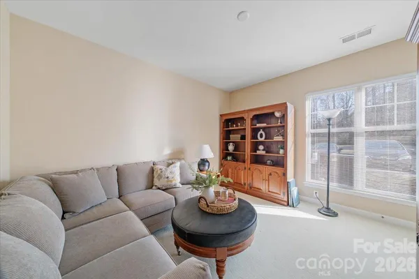 a living room with furniture and a floor to ceiling window
