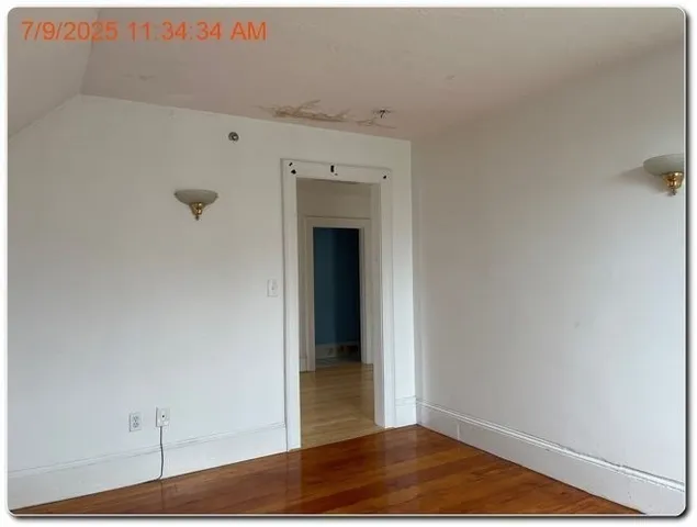 a view of a room with wooden floor