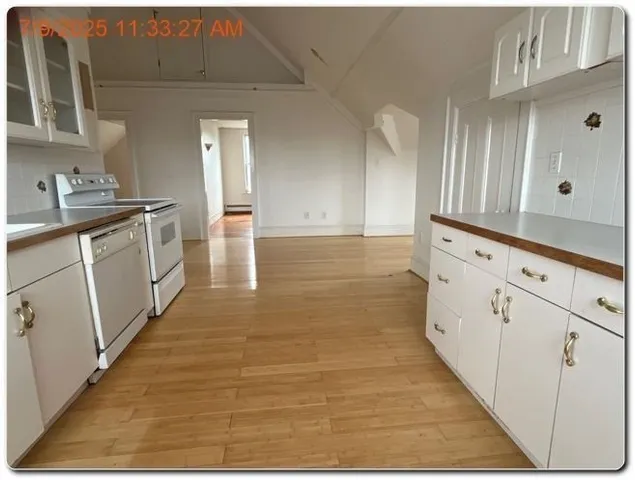 a kitchen with granite countertop white cabinets and white appliances
