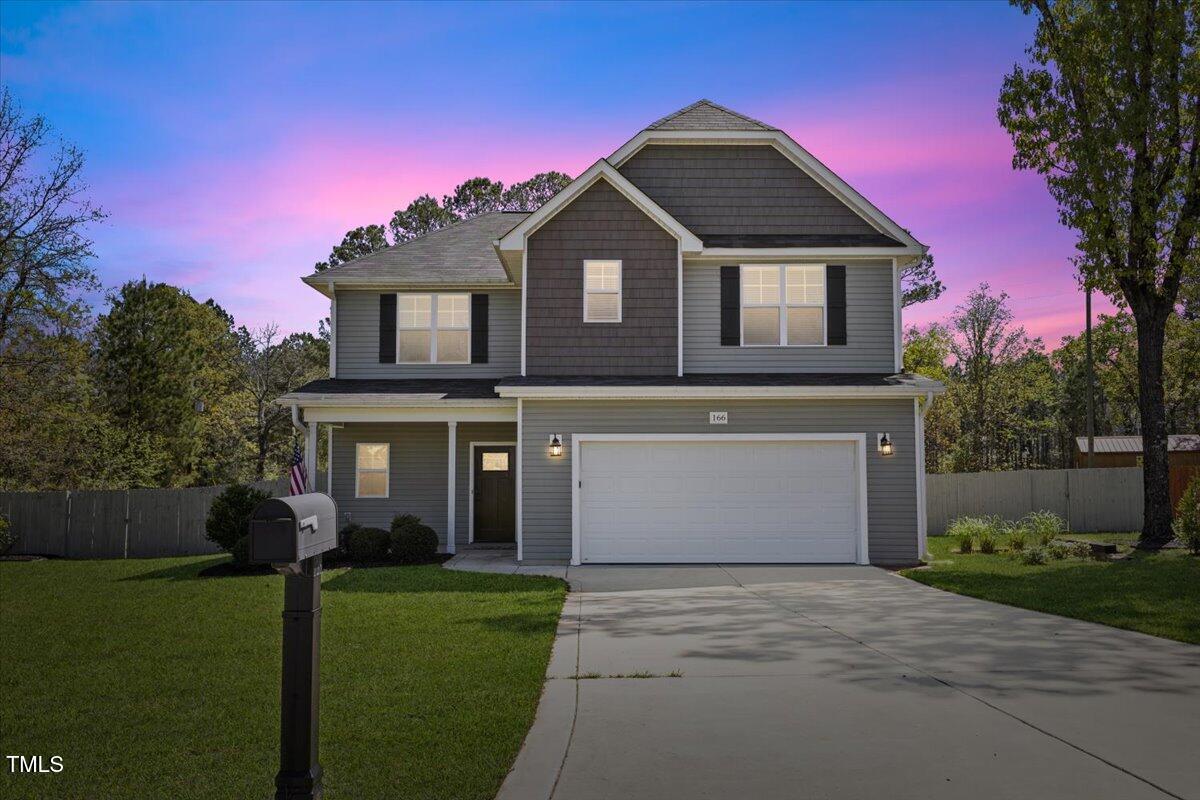 a front view of a house with a garden and yard