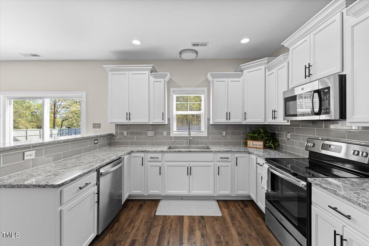 166 Old Field Loop Sanford, NC 27332 - Photo 15 of 50 a kitchen with a sink stove a microwave and cabinets