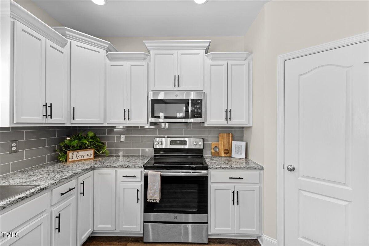 166 Old Field Loop Sanford, NC 27332 - Photo 16 of 50 a kitchen with white cabinets and appliances