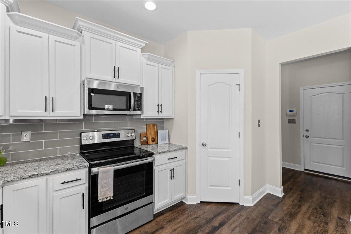 166 Old Field Loop Sanford, NC 27332 - Photo 19 of 50 a kitchen with white cabinets and appliances