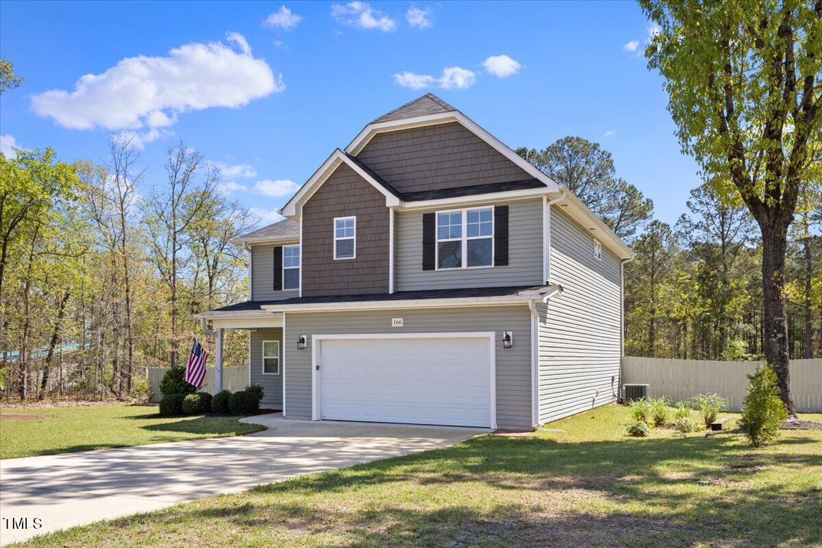166 Old Field Loop Sanford, NC 27332 - Photo 3 of 50 a front view of a house with a yard and garage