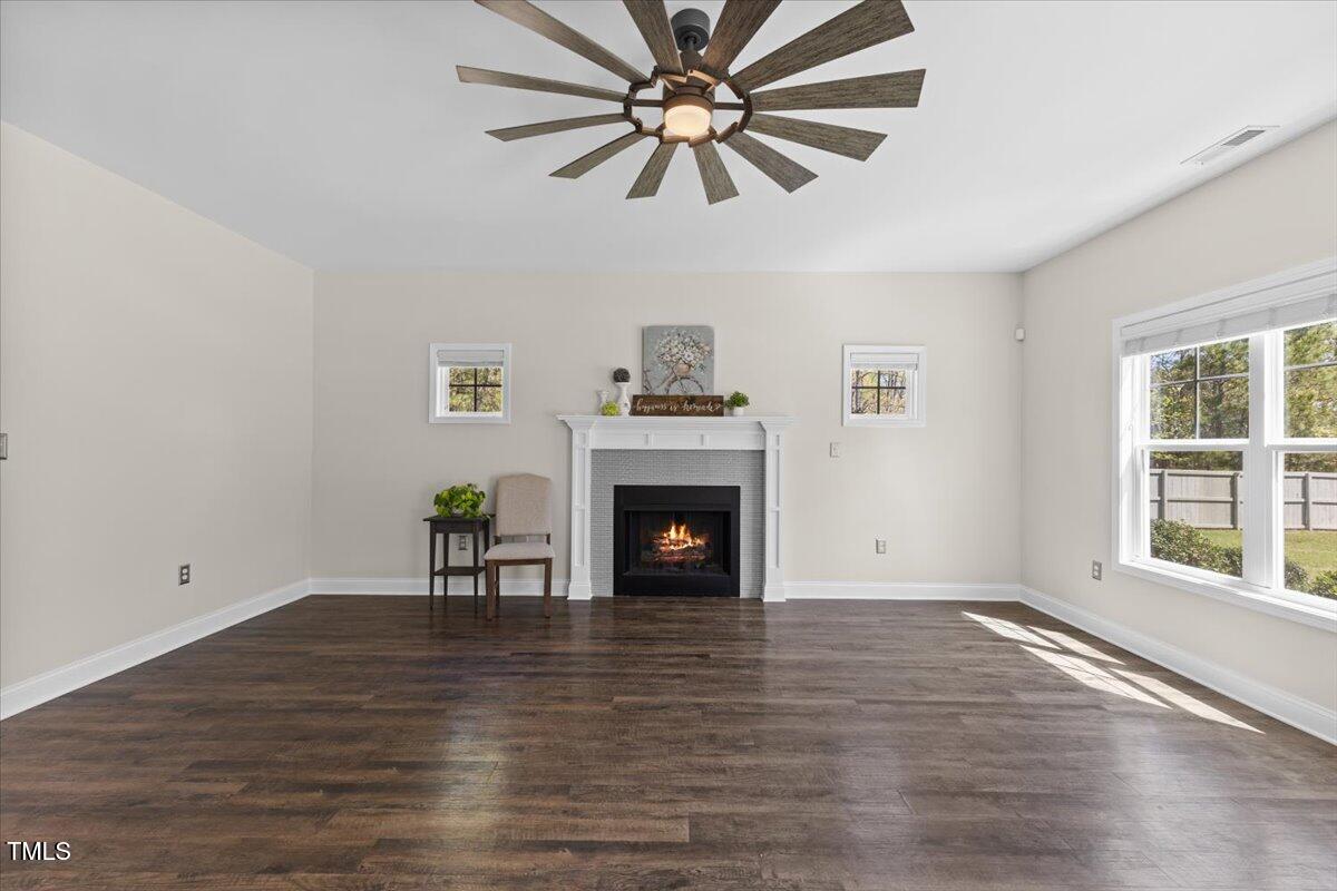 166 Old Field Loop Sanford, NC 27332 - Photo 8 of 50 a view of a livingroom with a fireplace a ceiling fan and windows