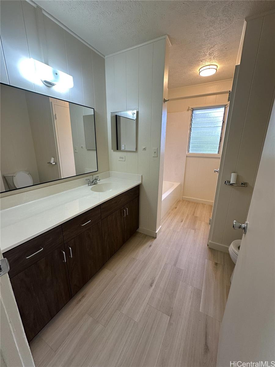 45-038 Waikalua Road Kaneohe, HI 96744 - Photo 11 of 16 a spacious bathroom with a vanity a sink a mirror and a toilet