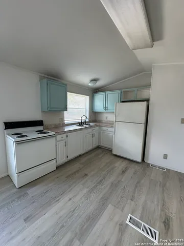 a kitchen with white cabinets and white appliances