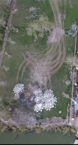 an aerial view of ocean and residential houses with outdoor space