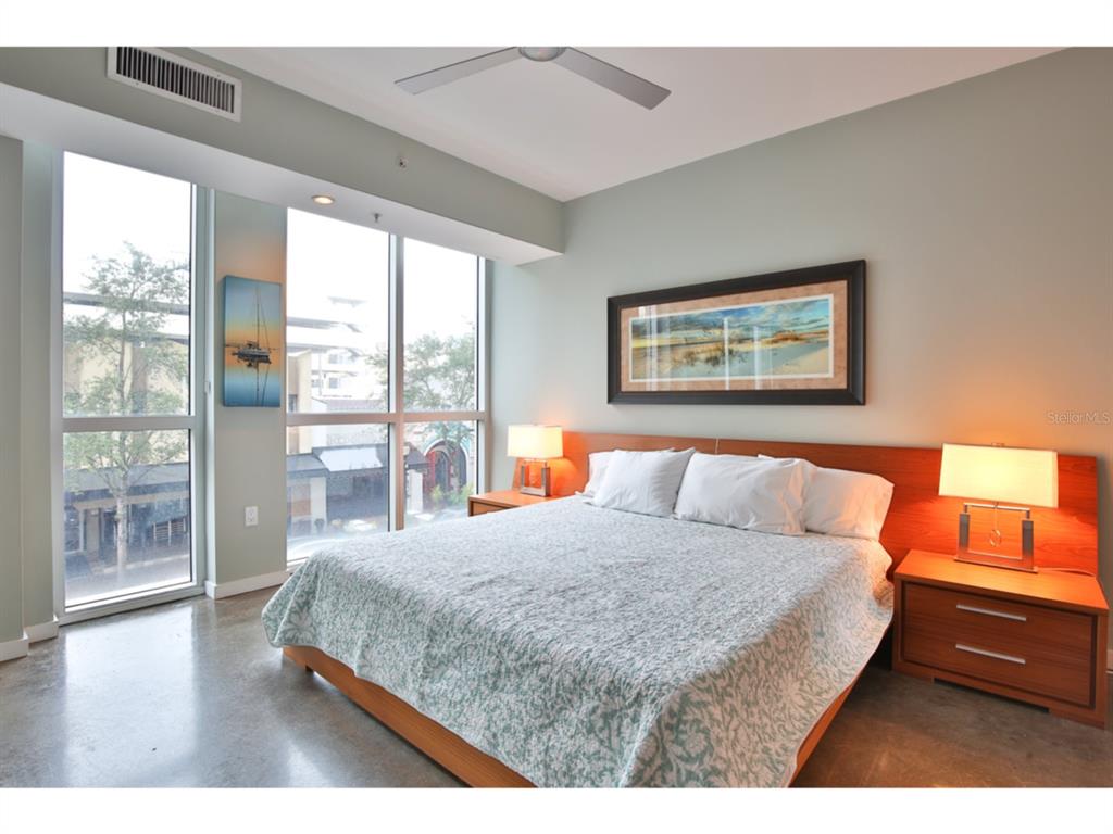 1350 Main Street, Unit 204 Sarasota, FL 34236 - Photo 13 of 22 a bedroom with a large bed and a large window