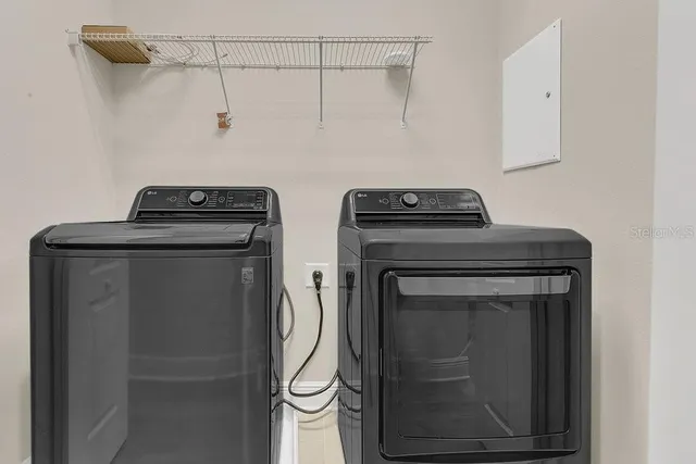 an empty room with wooden floor chandelier fan and windows