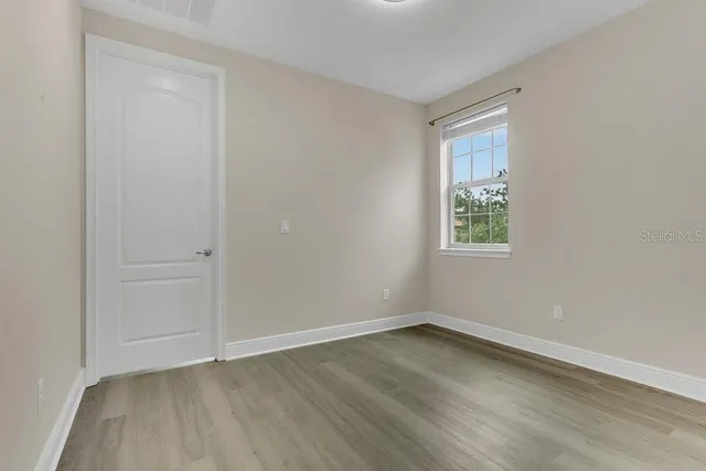 a view of an empty room with wooden floor