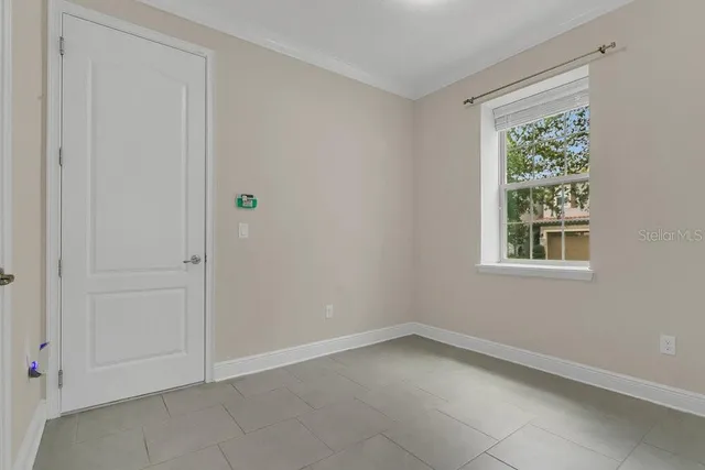 an empty room with windows and ceiling fan