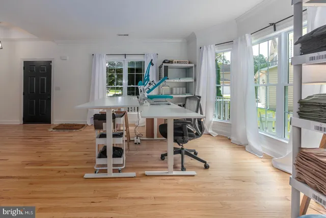 a work room with table chairs and wooden floor