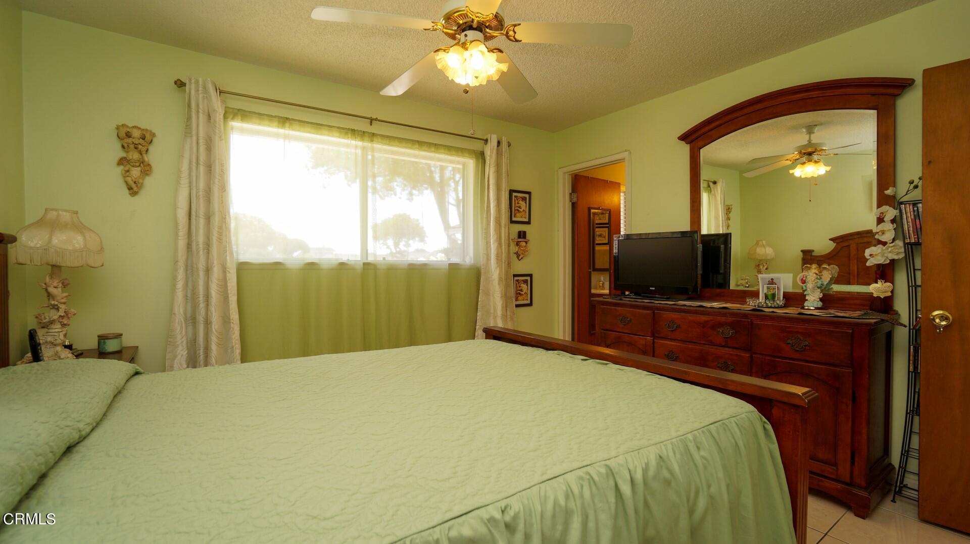 1121 Yale Street Oxnard, CA 93033 - Photo 11 of 22 a bedroom with a large bed and a flat tv screen on dresser